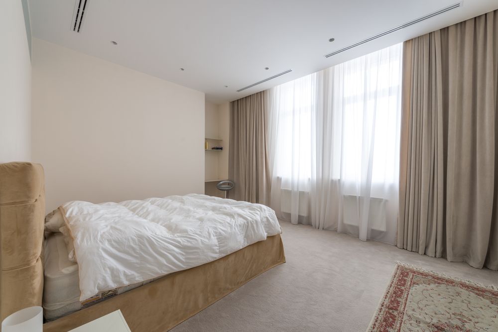 Bedroom with layered white and beige curtains