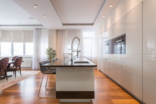 Free Interior of spacious kitchen with modern minimalist furniture with built in appliances and dining zone in contemporary apartment in daylight Stock Photo