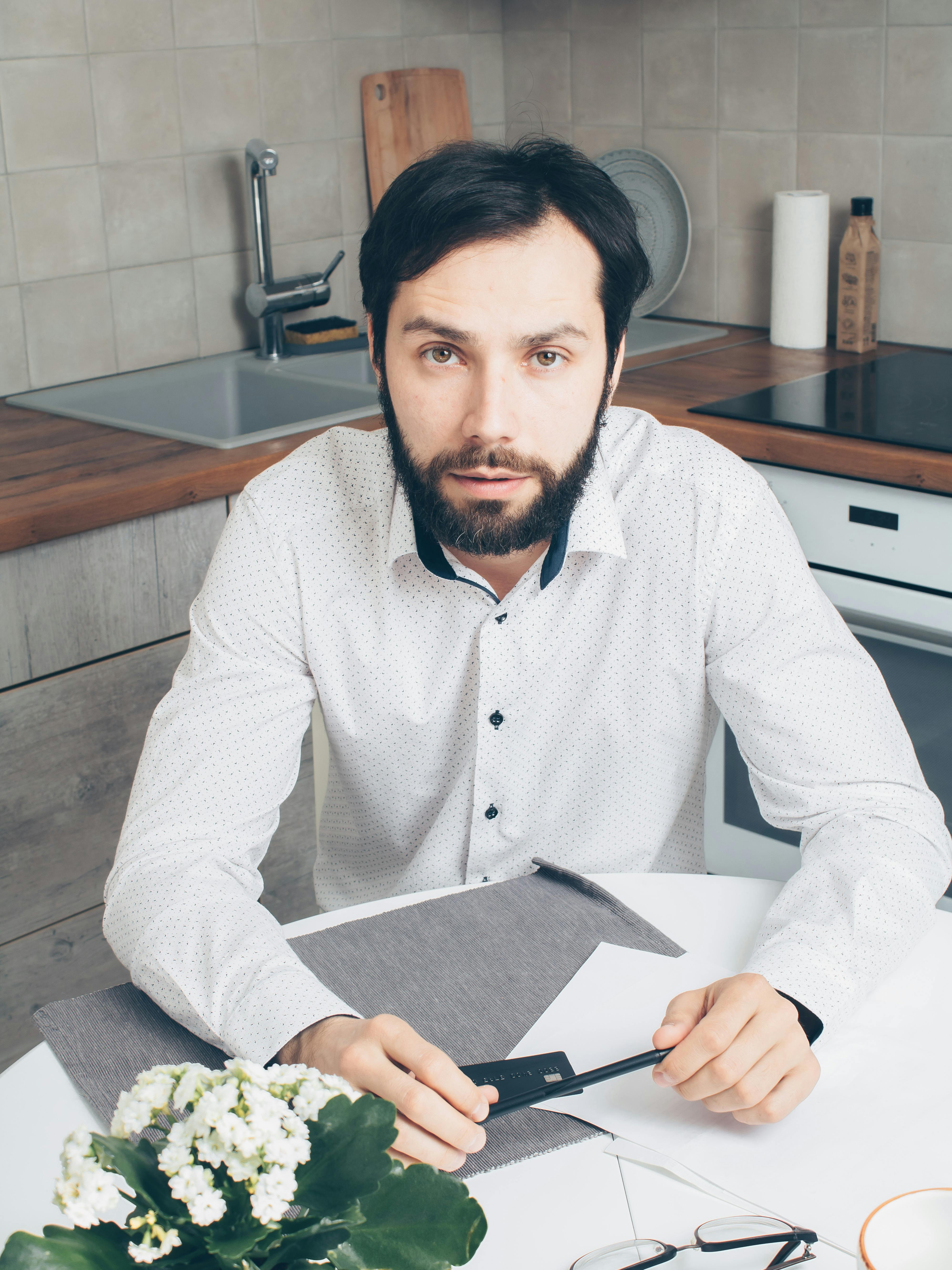 man in white dress shirt holding black tablet computer