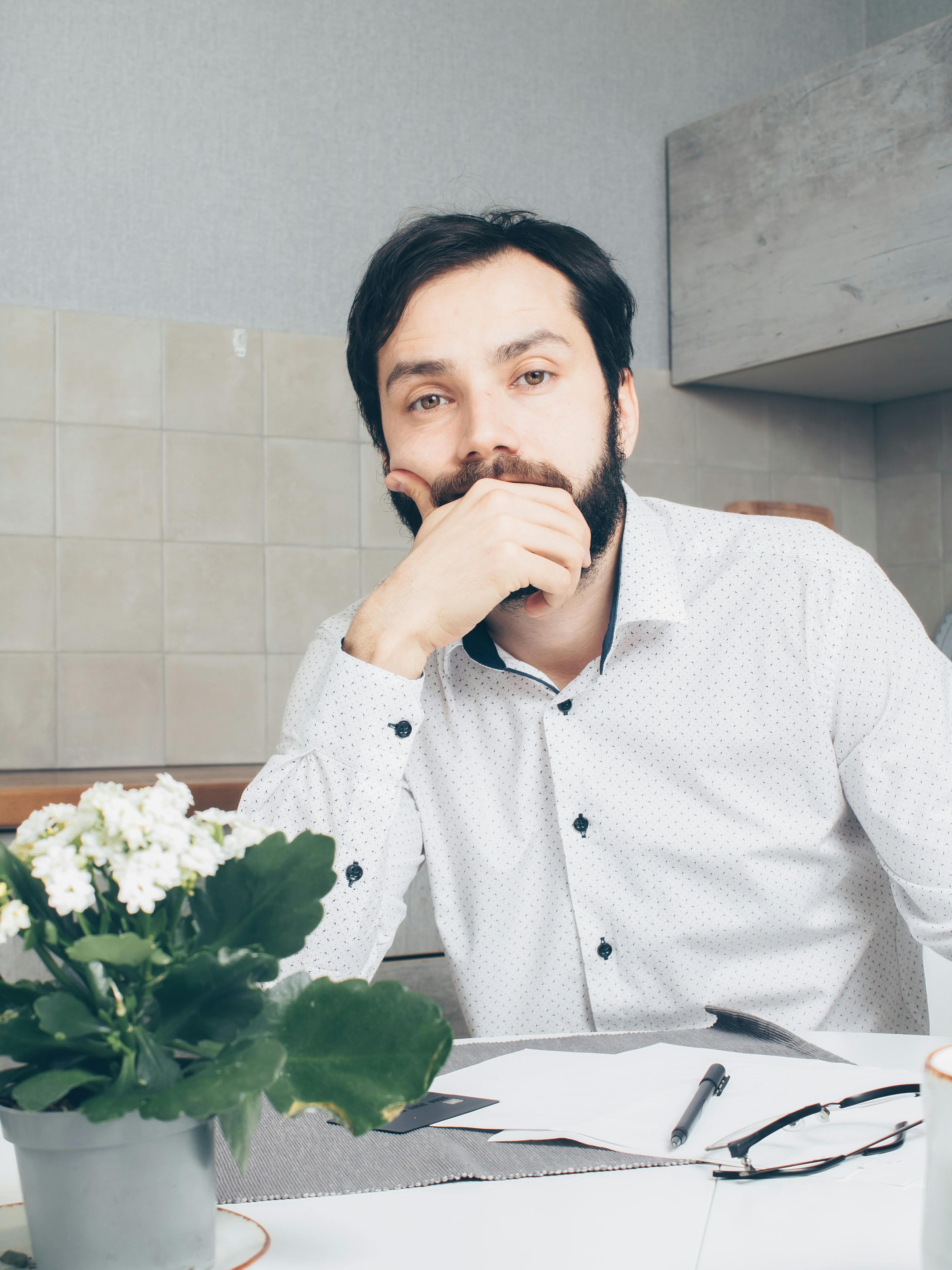 man in white dress shirt sitting at the table