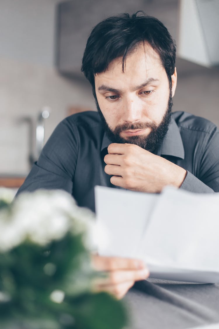 Man In Gray Shirt Holding Papers