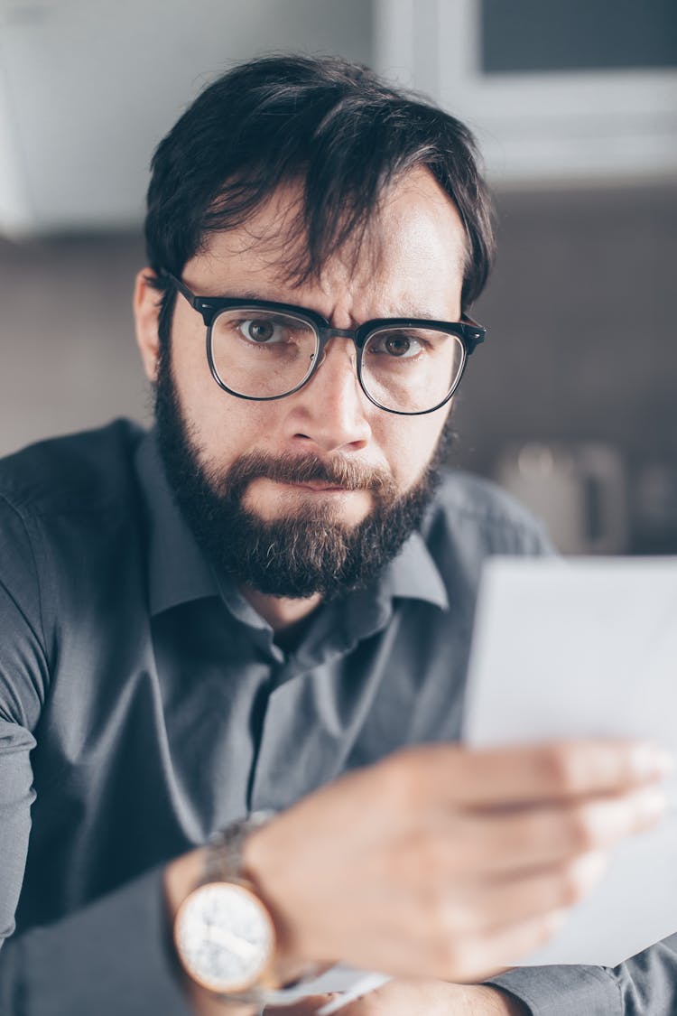 A Bearded Man Holding A Document