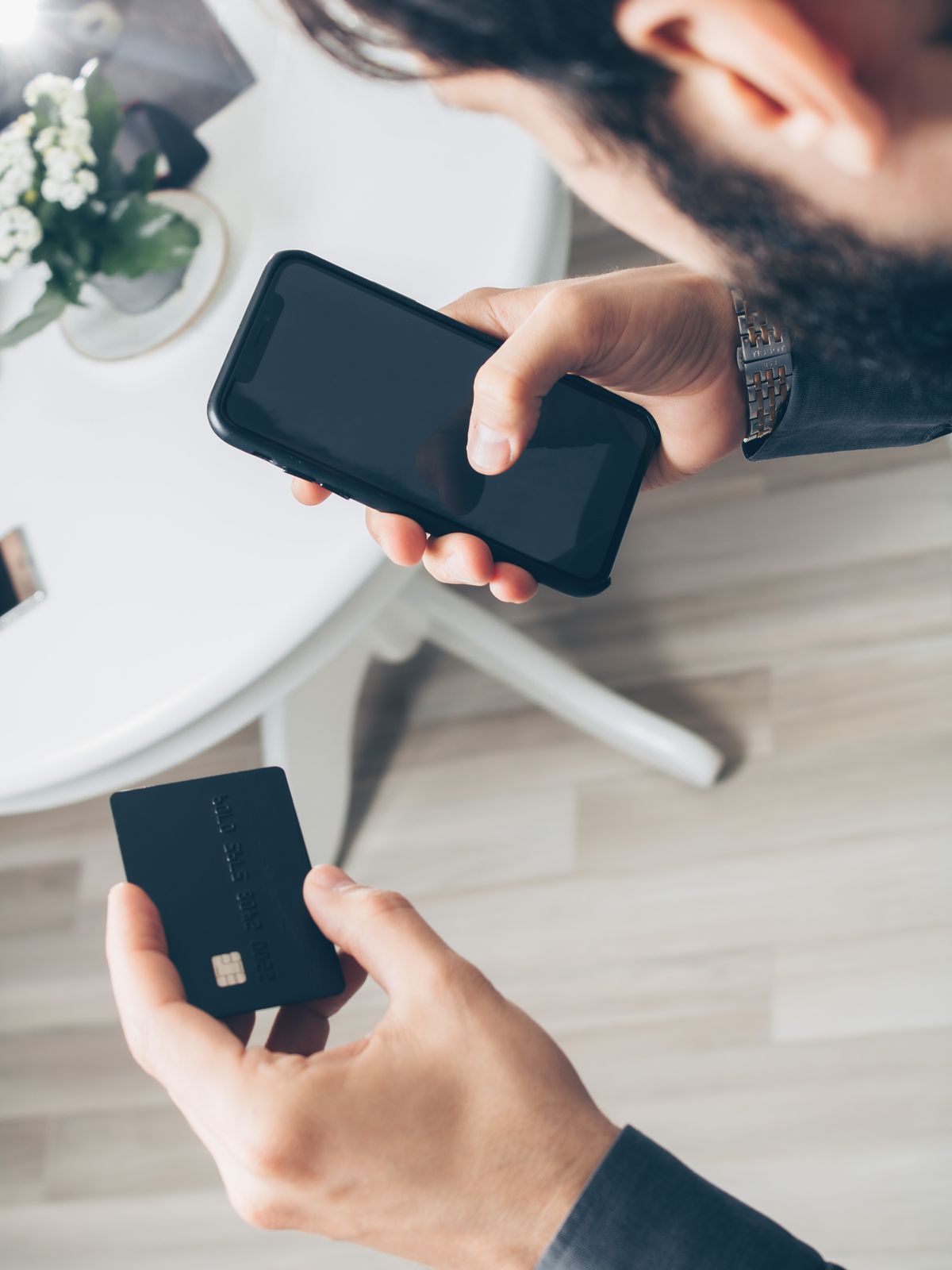 スマートフォンとクレジットカードを持つ手