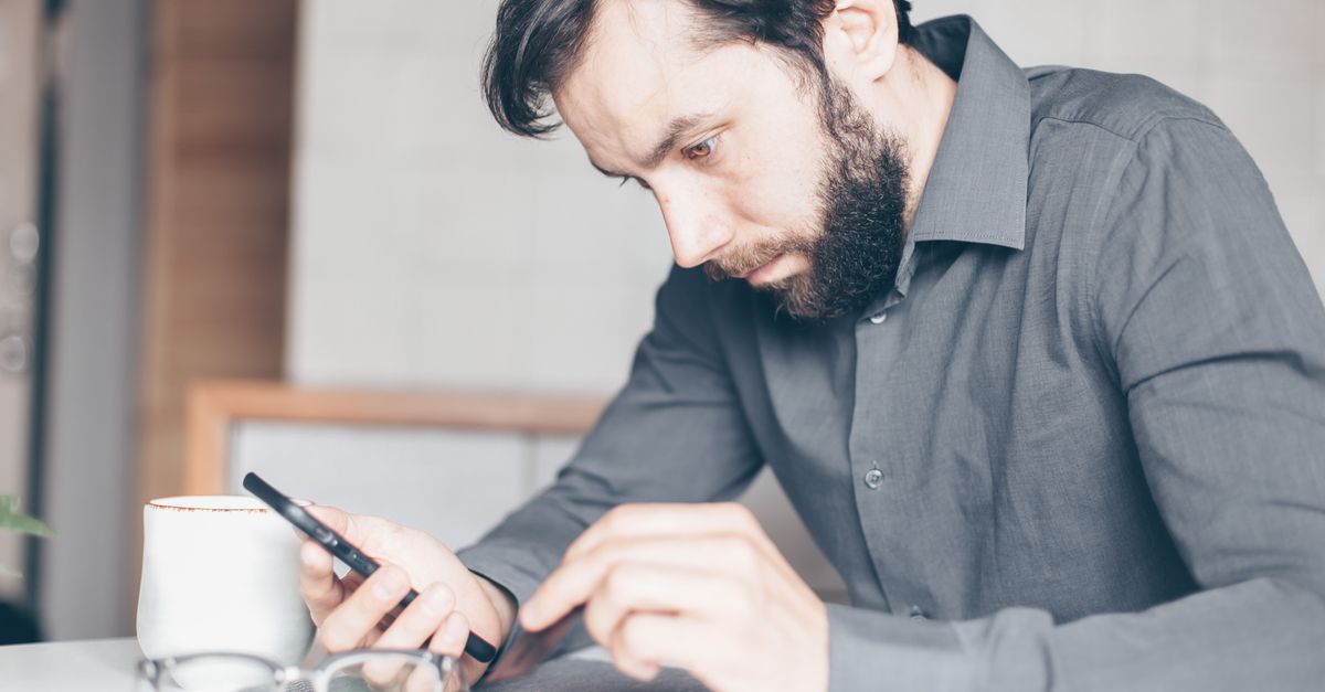 traveler reading hotel fine print on phone with confused expression