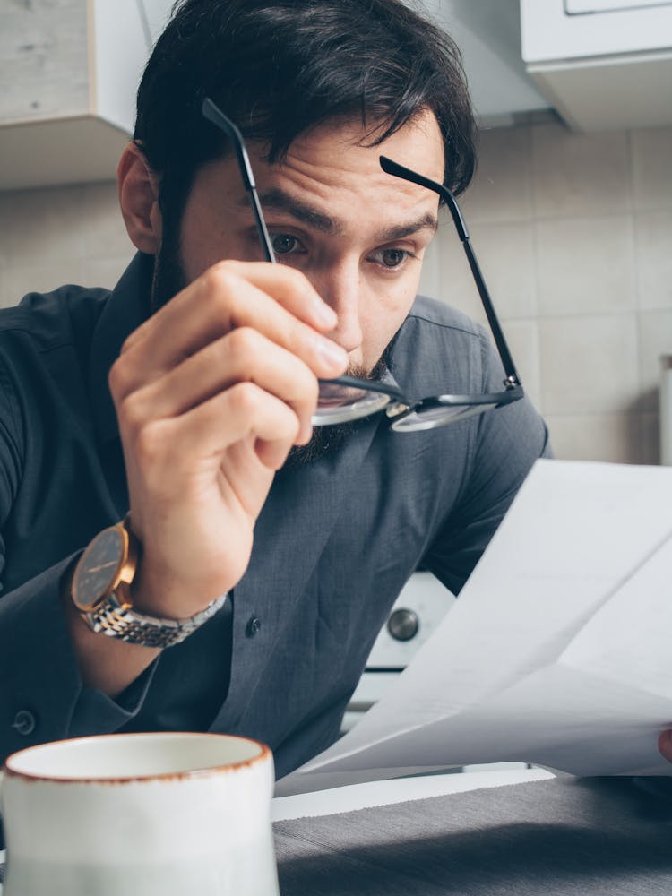 Man Reading A Paperwork With A Serious Face