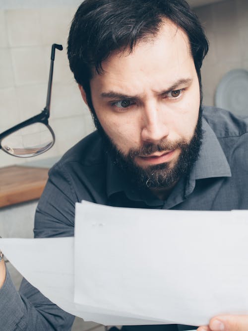 Man Reading Paperwork and Feeling Shocked