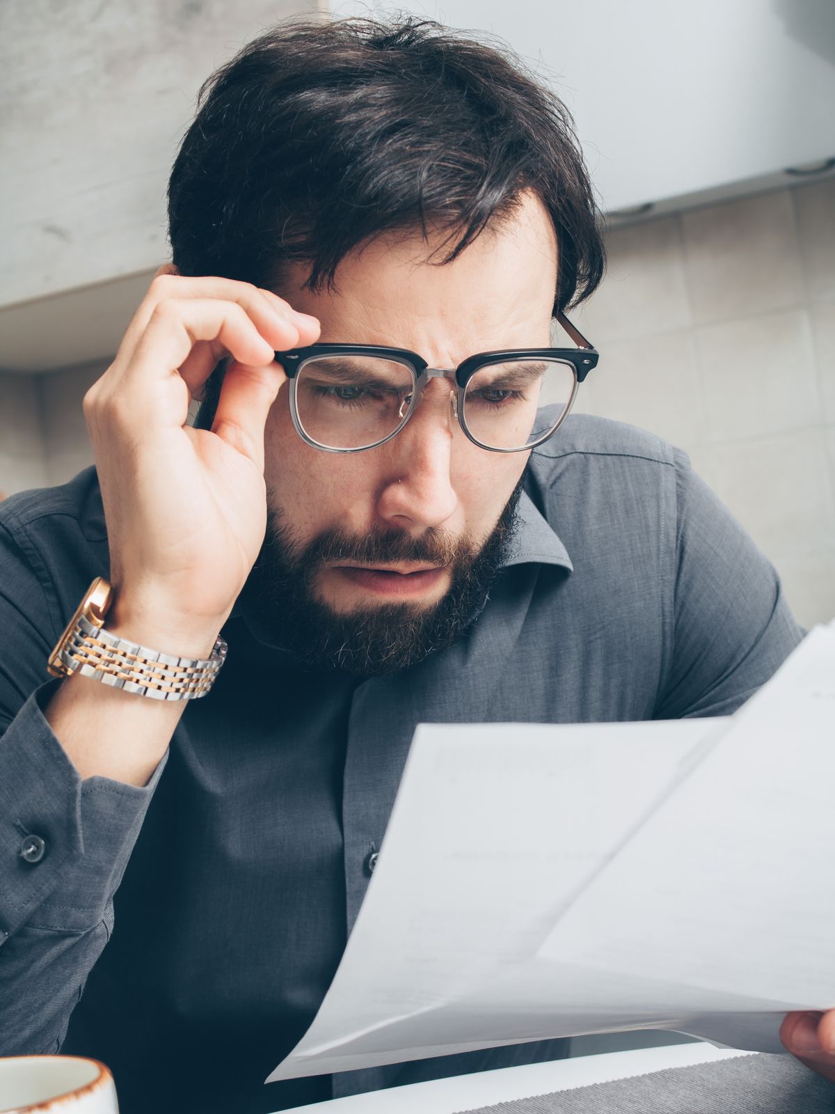 Persoană îngrijorată care analizează facturi și documente financiare