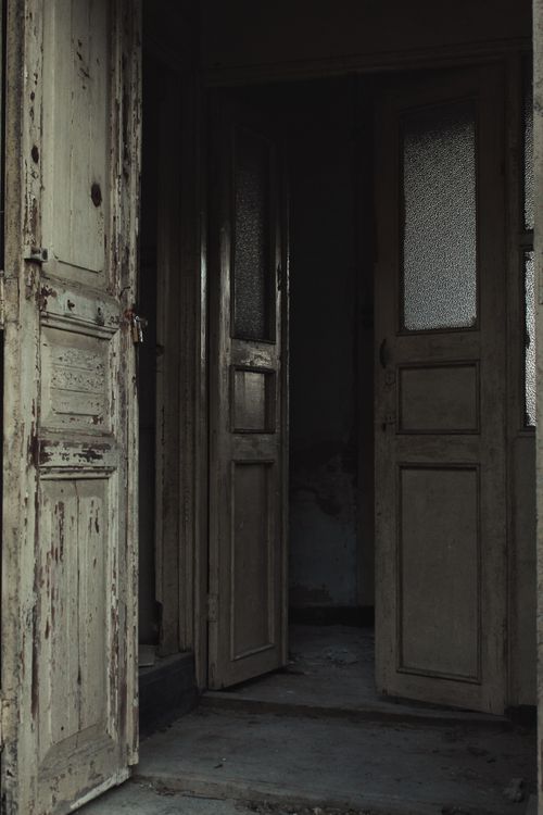 Free Interior of aged peeling shabby wooden doors and frayed floor of abandoned dilapidated house Stock Photo