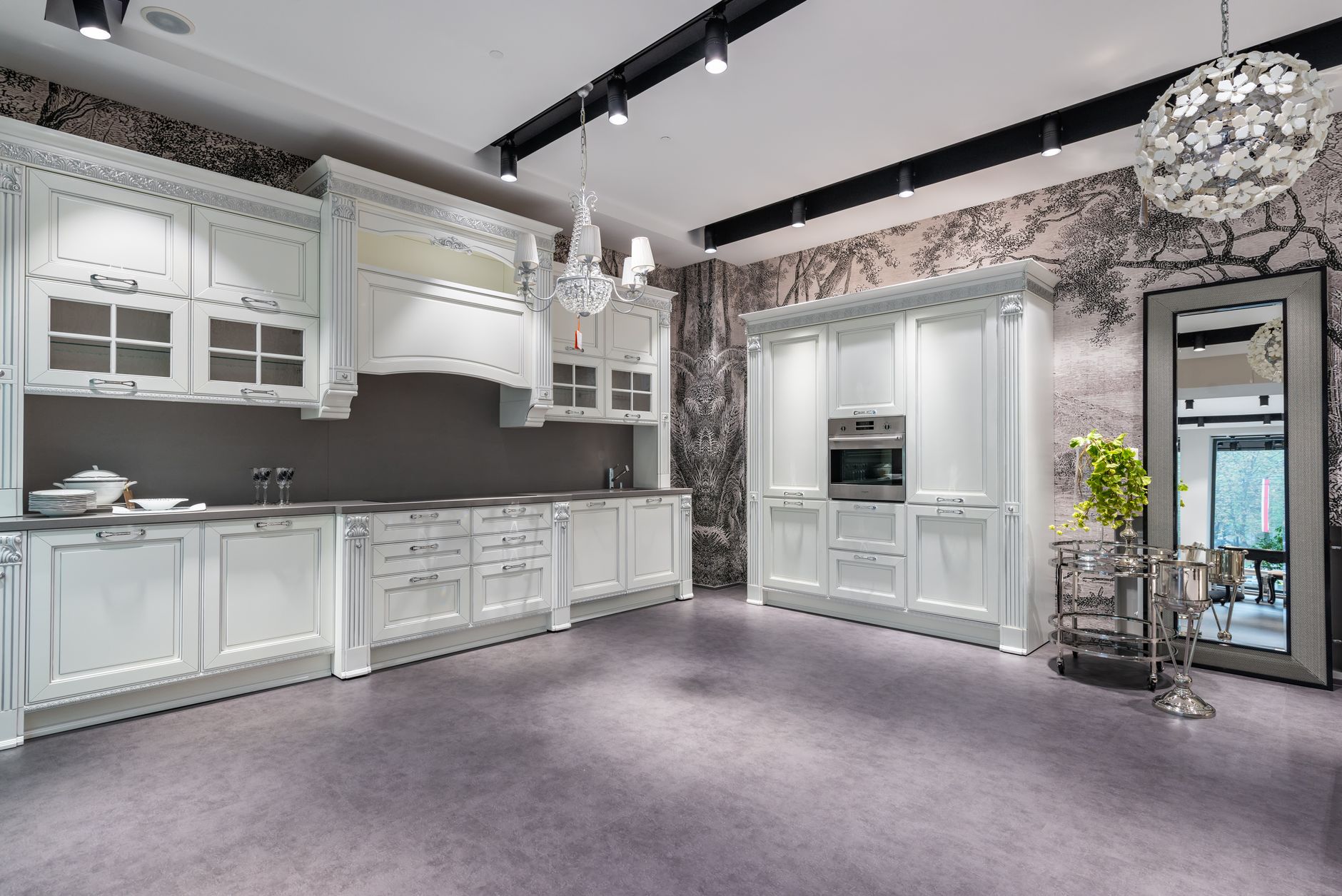 high end kitchen transformation for modern homes White cabinets with dishware in spacious stylish kitchen with oven and side table near window and potted plant in apartment