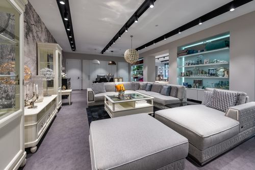 Free Comfortable sofa with cushions near table placed in spacious modern apartment with white cabinet and various decorative elements on shelves Stock Photo