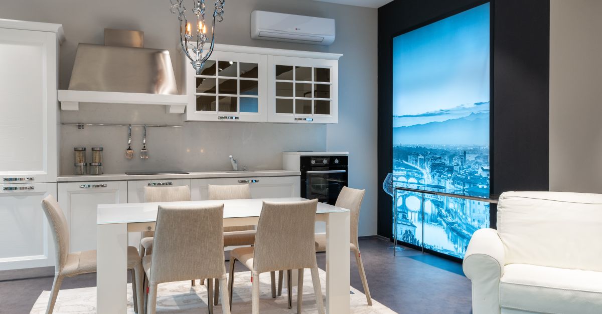 Interior of stylish light kitchen with white furniture and dining area ...