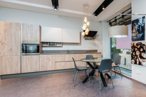 Free Interior of spacious kitchen zone with wooden cabinets and round glass table in contemporary flat Stock Photo