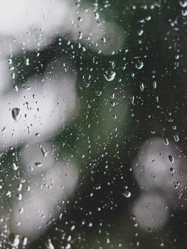 Close-up view of raindrops on a glass window capturing rainy weather outdoors.