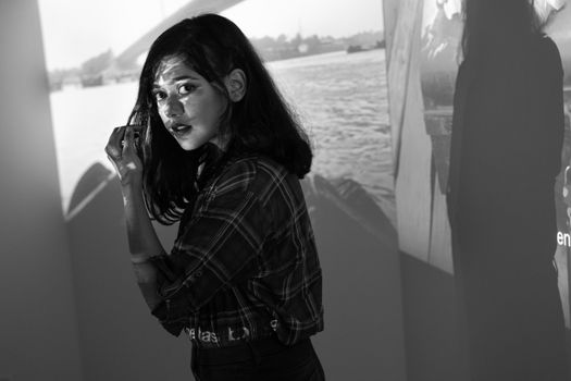 Young Woman Standing with Her Face Illuminated by the Projection 