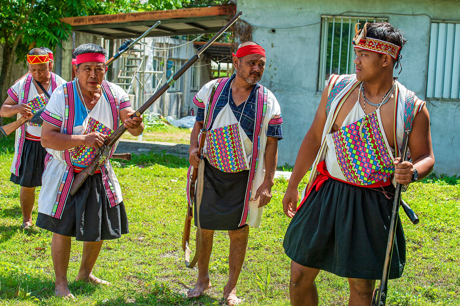 Group of men in traditional Taiwanese indigenous clothing outdoors, showcasing cultural heritage and craftsmanship.