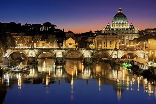 Beautiful view of Saint Peter's Basilica and St. Angelo Bridge in Rome at sunset reflecting in the Tiber River. by Julius Silver