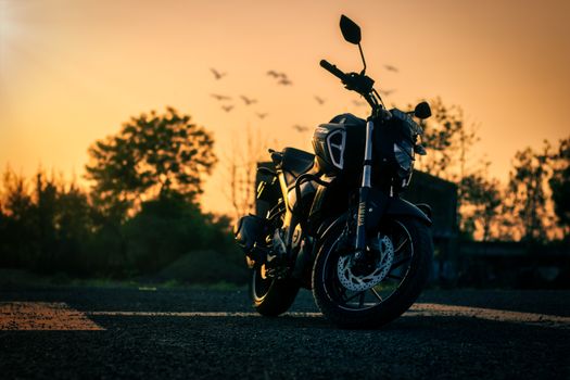 A striking sports motorbike at sunrise with a serene Indian backdrop.