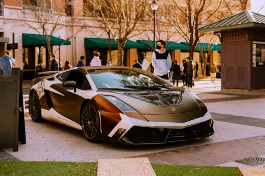 Sleek Lamborghini Gallardo parked outdoors with people in background, urban setting.