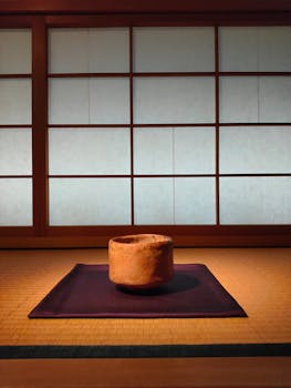 Elegant tea room in Kyoto with a clay bowl on a tatami mat.