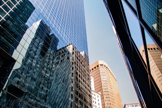 Dynamic view of skyscrapers reflecting each other in New York City, showcasing urban architecture.