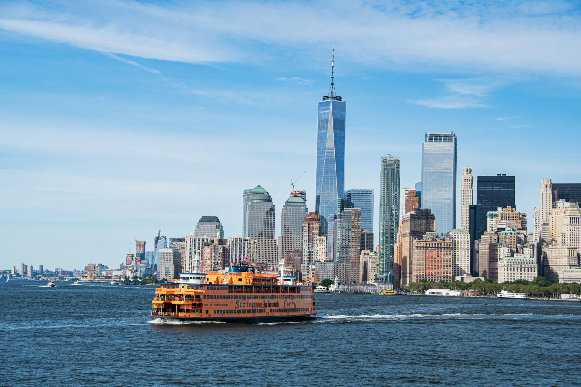 Scenic view of Staten Island Ferry crossing with New York City skyline backdrop.
