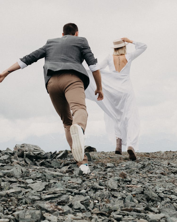 Anonymous Groom Catching Up Bride On Rocky Land