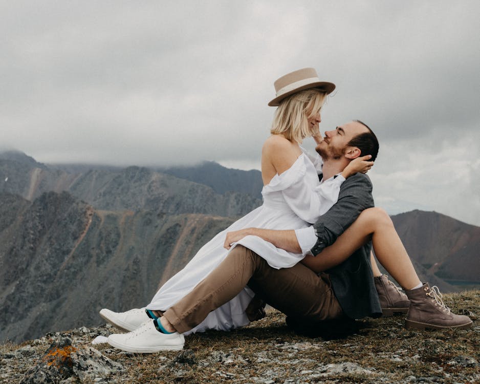 Romantic couple hugging and looking at each other while sitting on mountain