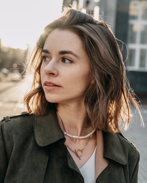 Woman in coat on street in sunlight