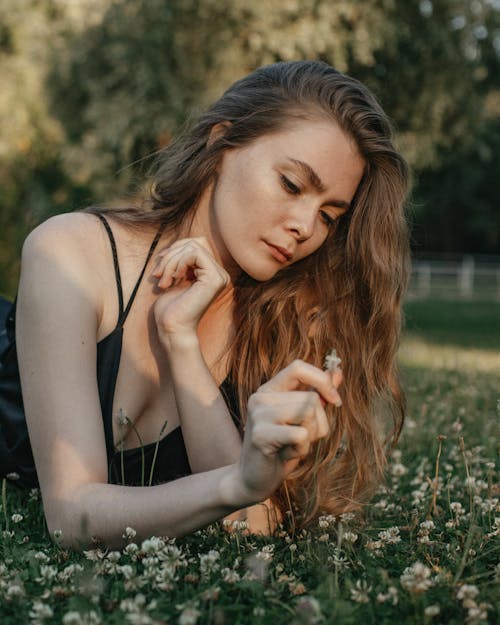 Dreamy woman with wildflowers in park