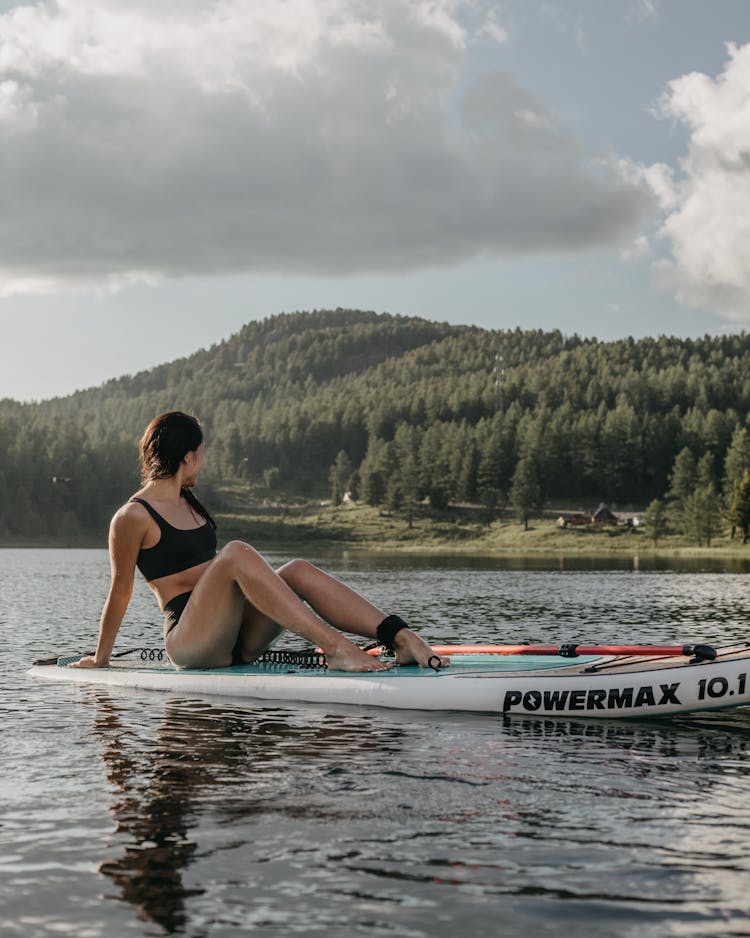 Woman Looking Back While Floating On Paddleboard