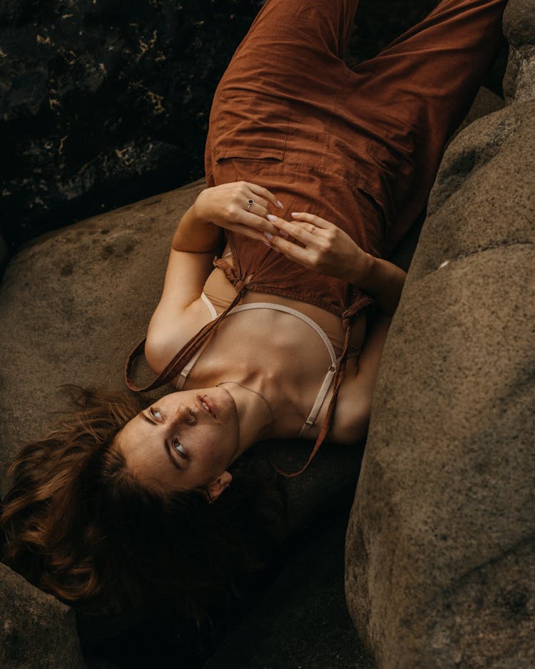 Thoughtful Woman Lying On Stone