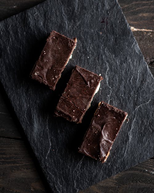 Free Top view of square cut chocolate pastries served on slate board in row Stock Photo