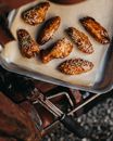 Delicious chicken wings baked in oven with teriyaki sauce and sprinkled with sesame seeds placed on baking sheet of paper