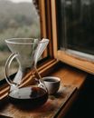 Chemex with coffee and cup near window
