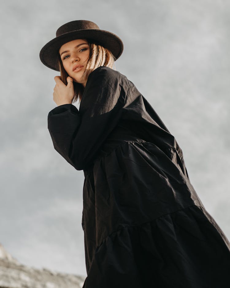 Stylish Woman In Black Outfit Standing In Nature