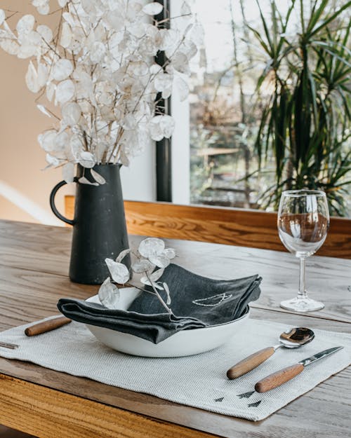 Artificial bouquet and dishware placed on table