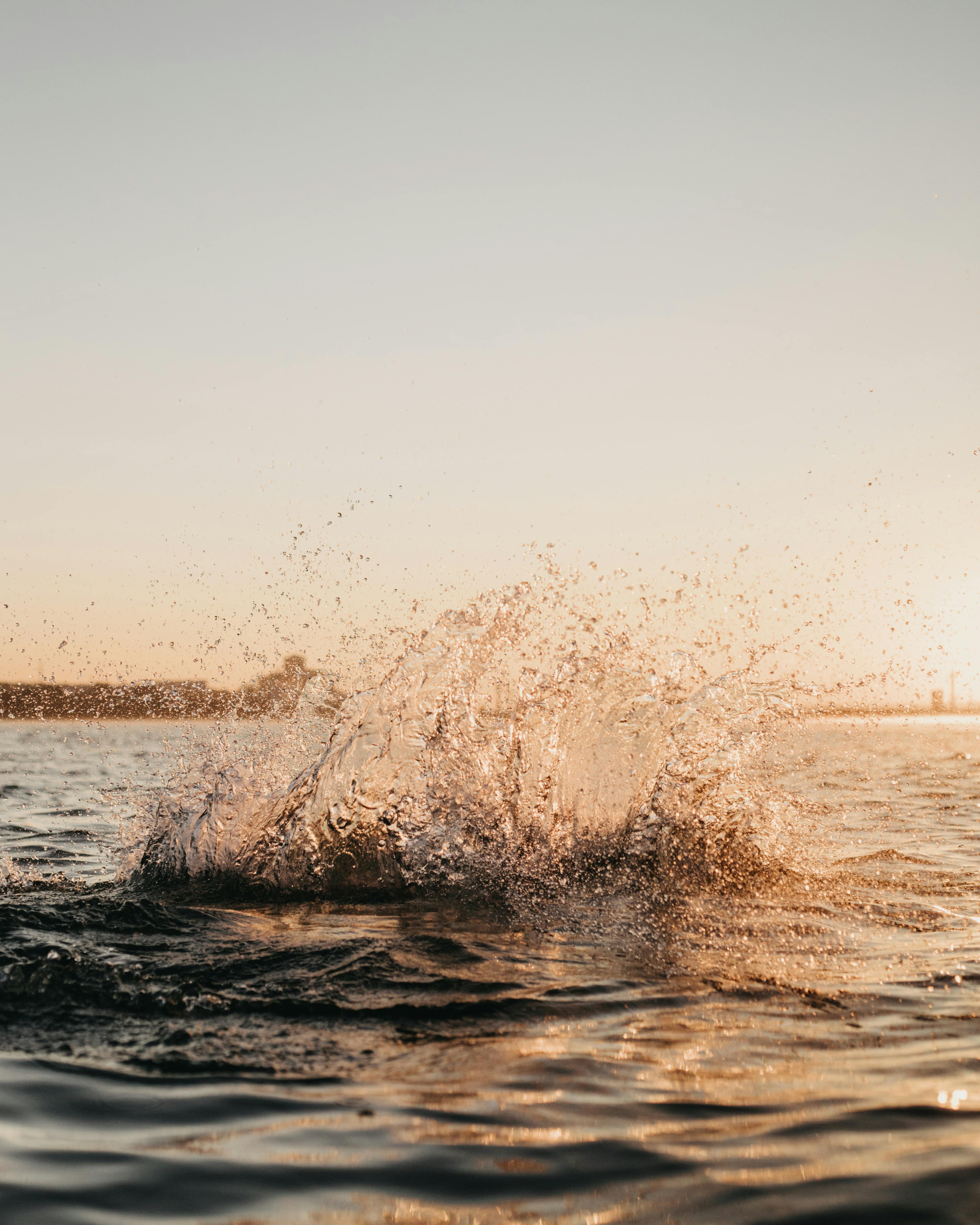 Captivating ocean splash captured during sunrise, showcasing nature's serene beauty.
