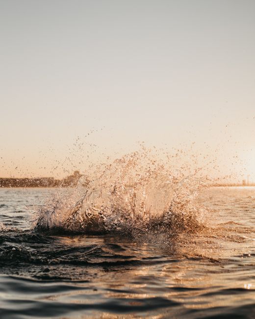 Captivating ocean splash captured during sunrise, showcasing nature's serene beauty.