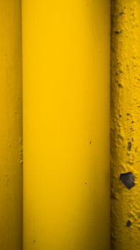 Close-up of a bright yellow industrial pipe with textured surface.