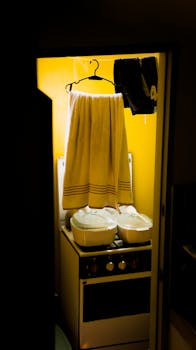 Bright indoor laundry setup with hanging towels and cooking pots on a stove.