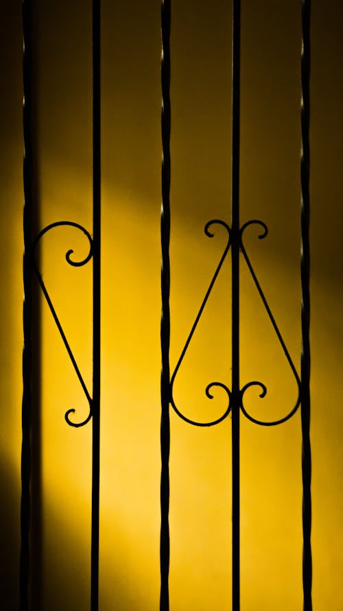 Metal railing on background of yellow wall