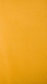 Close-up texture of a vibrant yellow wall, perfect for design and background use.