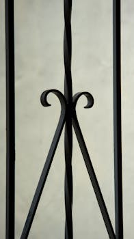 Detailed close-up of an elegant black iron railing with artistic design.