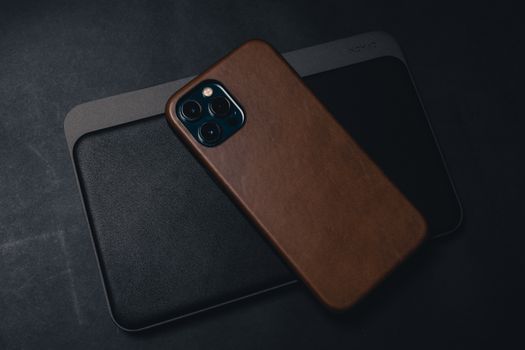 Close-up of a smartphone with leather case placed on a tablet, showcasing modern technology.