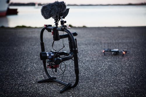 Free Shallow Focus Photography of Black Quadcopter Near Body of Water Stock Photo