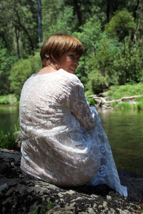 Woman in White Lace Dress sitting on Lakeside