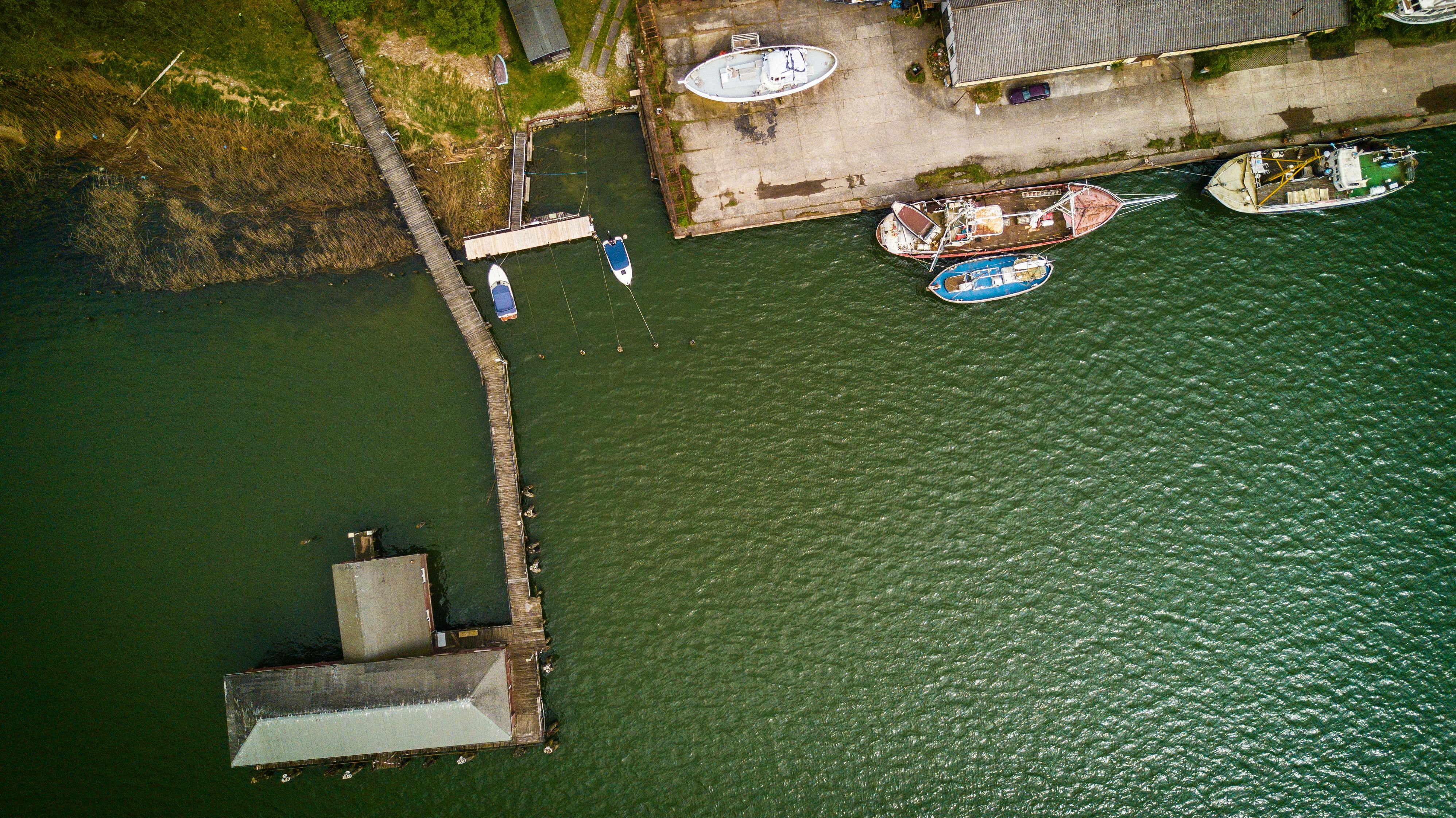 bird s eye view of boat near dock on calm body of water