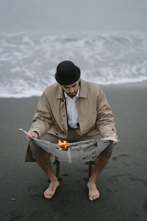 Man wearing Beige Coat reading Newspaper 