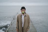 Man in Beige Coat holding Green Apple