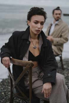 Elegant fashion pose on a rocky seaside with a stylish jacket.